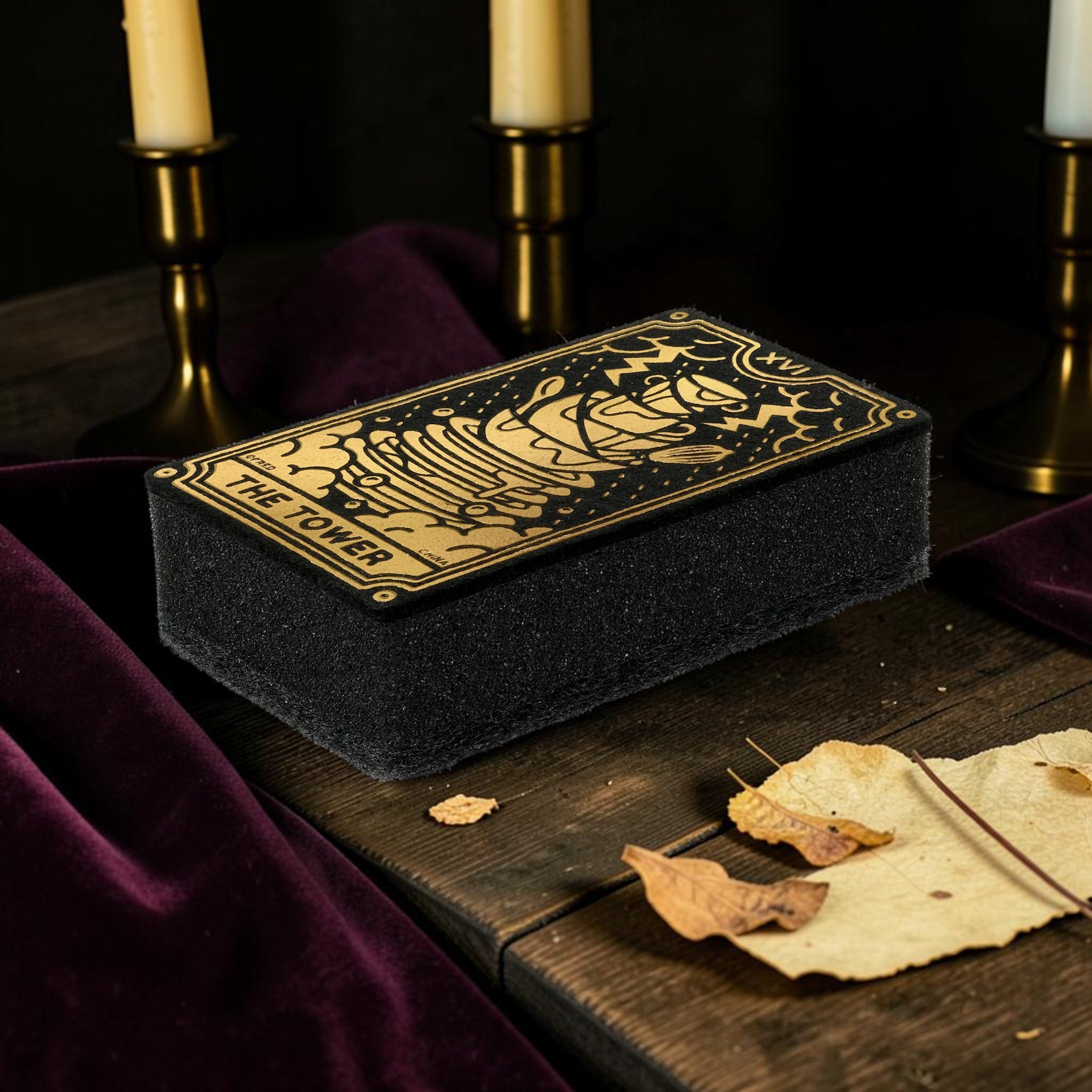 Halloween-Emporium The Tower tarot card kitchen sponge with metallic gold illustration on a dark wooden table