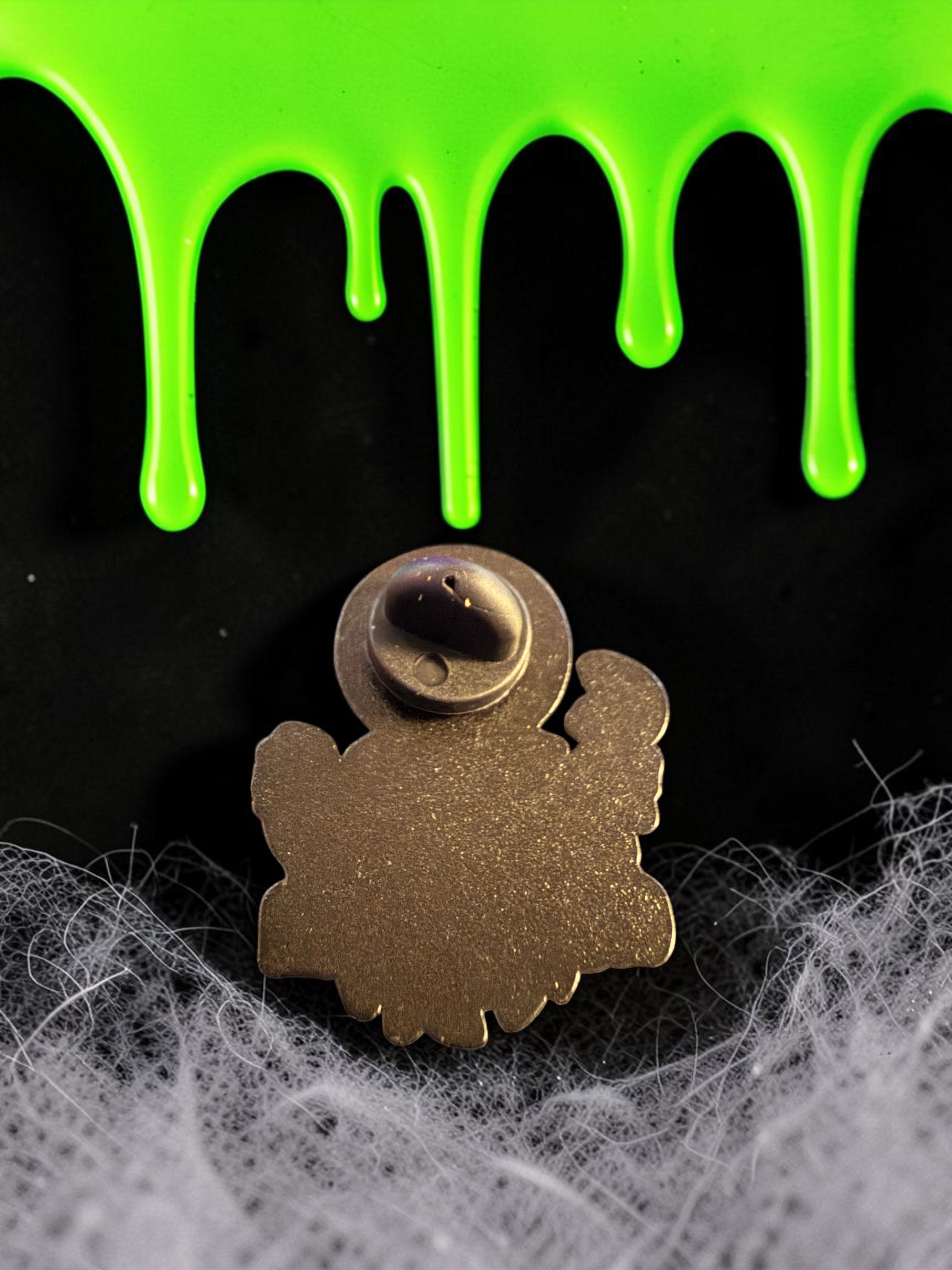Halloween-Emporium Trick 'r' Treat Sam's Rules of Halloween enamel pin back view on a spooky black and green background