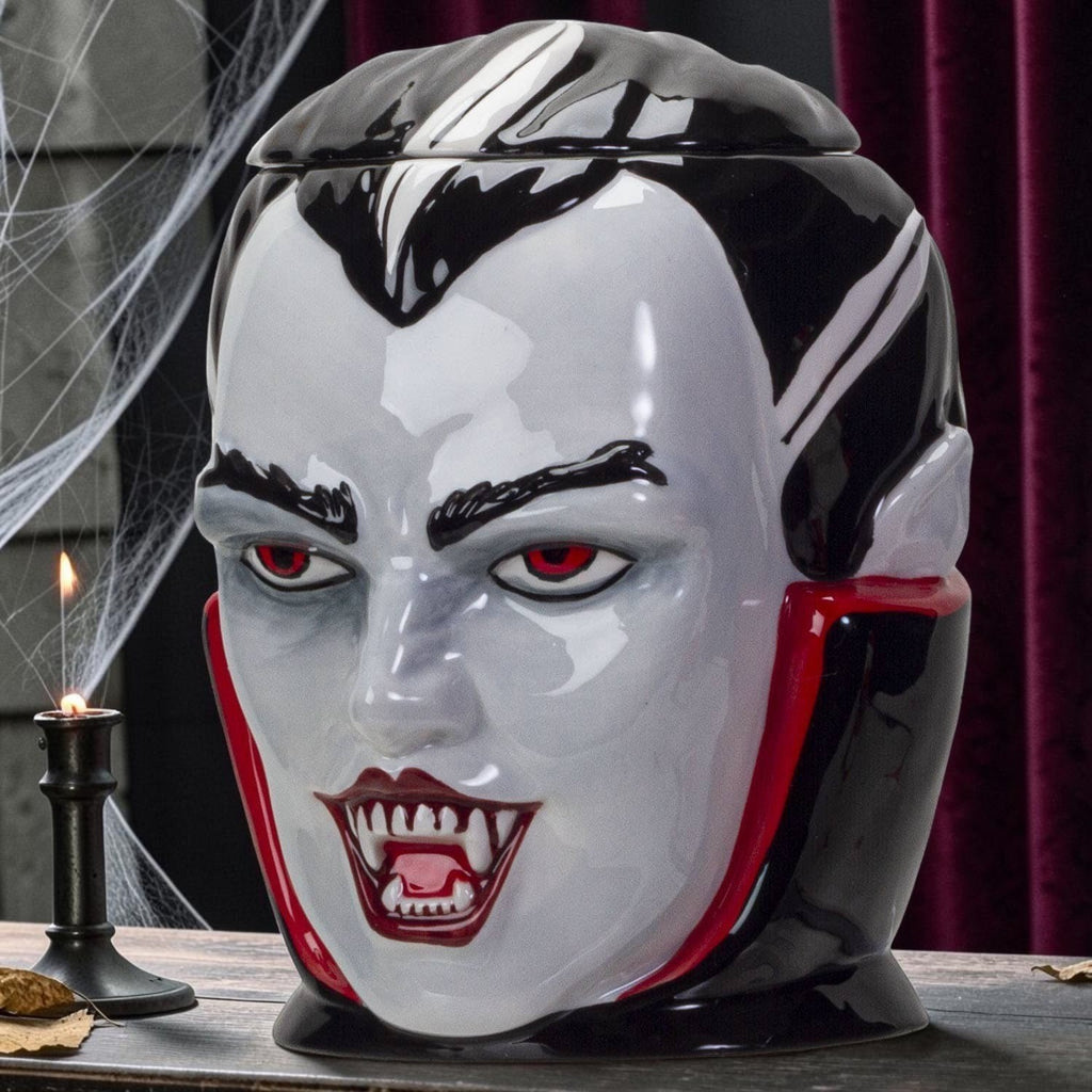 Halloween-Emporium vampire ceramic treat jar with glossy finish, red eyes, and fangs for spooky home decor.