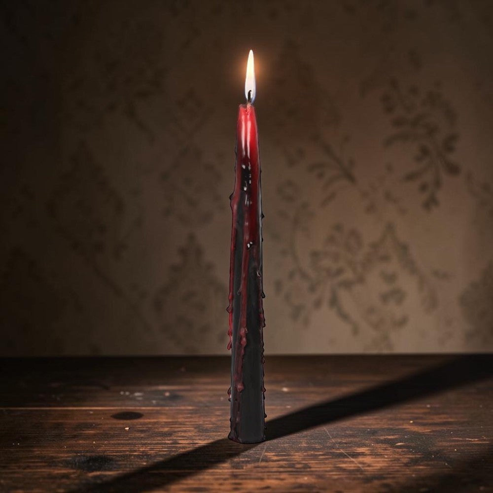 Halloween-Emporium Vampire Tears taper candle with a black exterior melting to reveal a crimson red bleeding wax core.