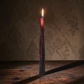 Halloween-Emporium Vampire Tears taper candle with a black exterior melting to reveal a crimson red bleeding wax core.