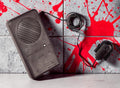 Halloween-Emporium voice changing sound effect accessory with black speaker and microphone on a blood-splattered wall