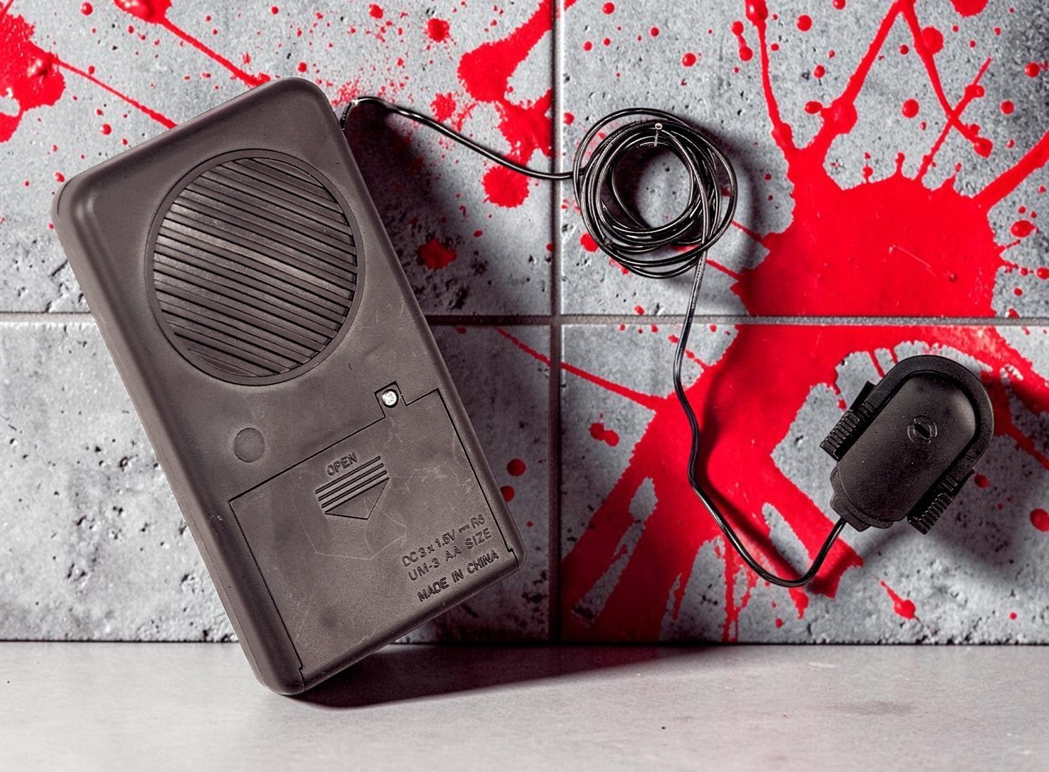 Halloween-Emporium voice changing sound effect accessory with black speaker and microphone on a blood-splattered wall