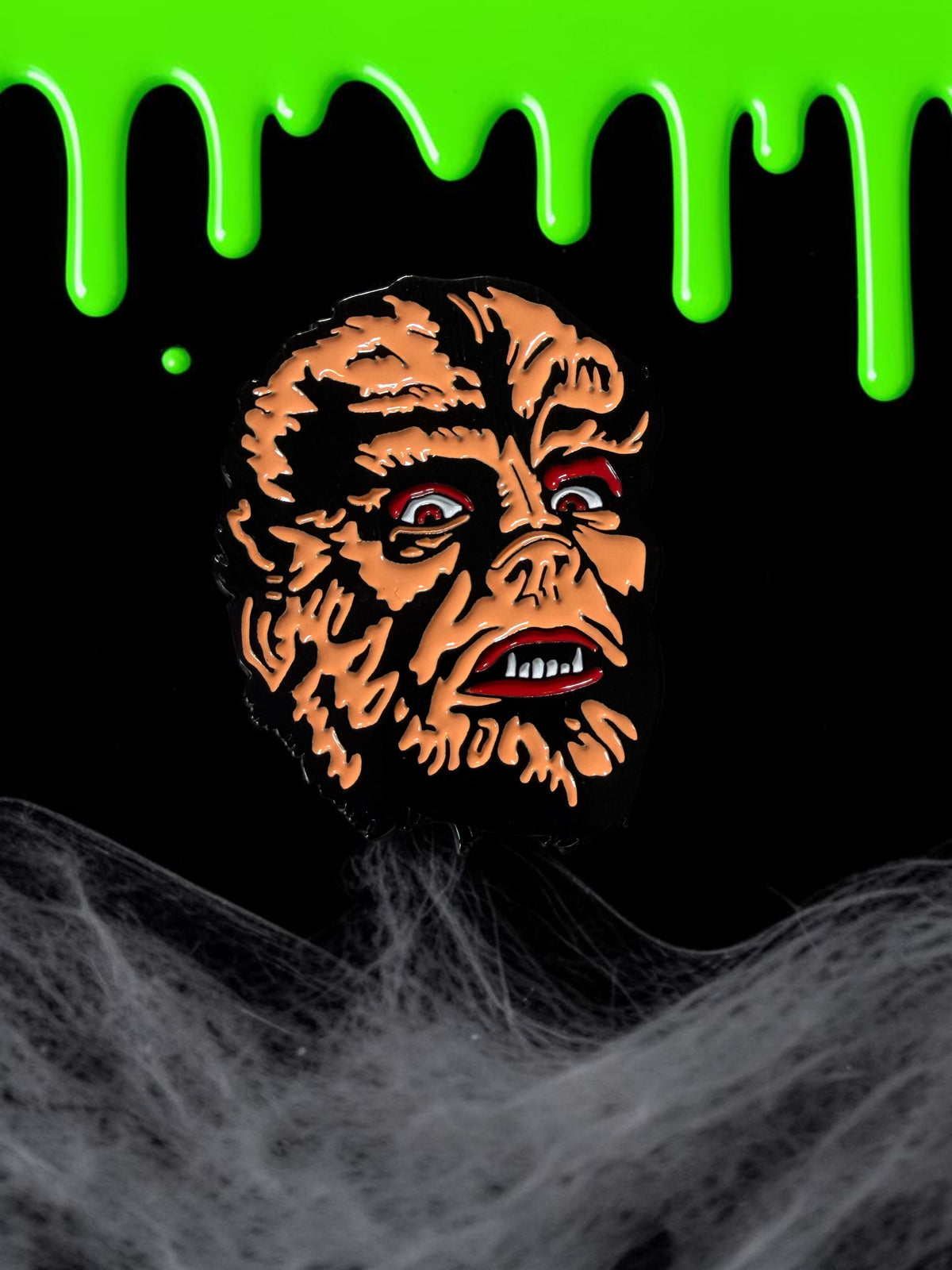 Halloween-Emporium 1.5-inch soft enamel werewolf pin featuring a detailed monster face with red eyes and sharp teeth.