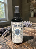 Halloween-Emporium alcohol-free witch hazel toner in a spray bottle with vintage-style label on a rustic wooden table.