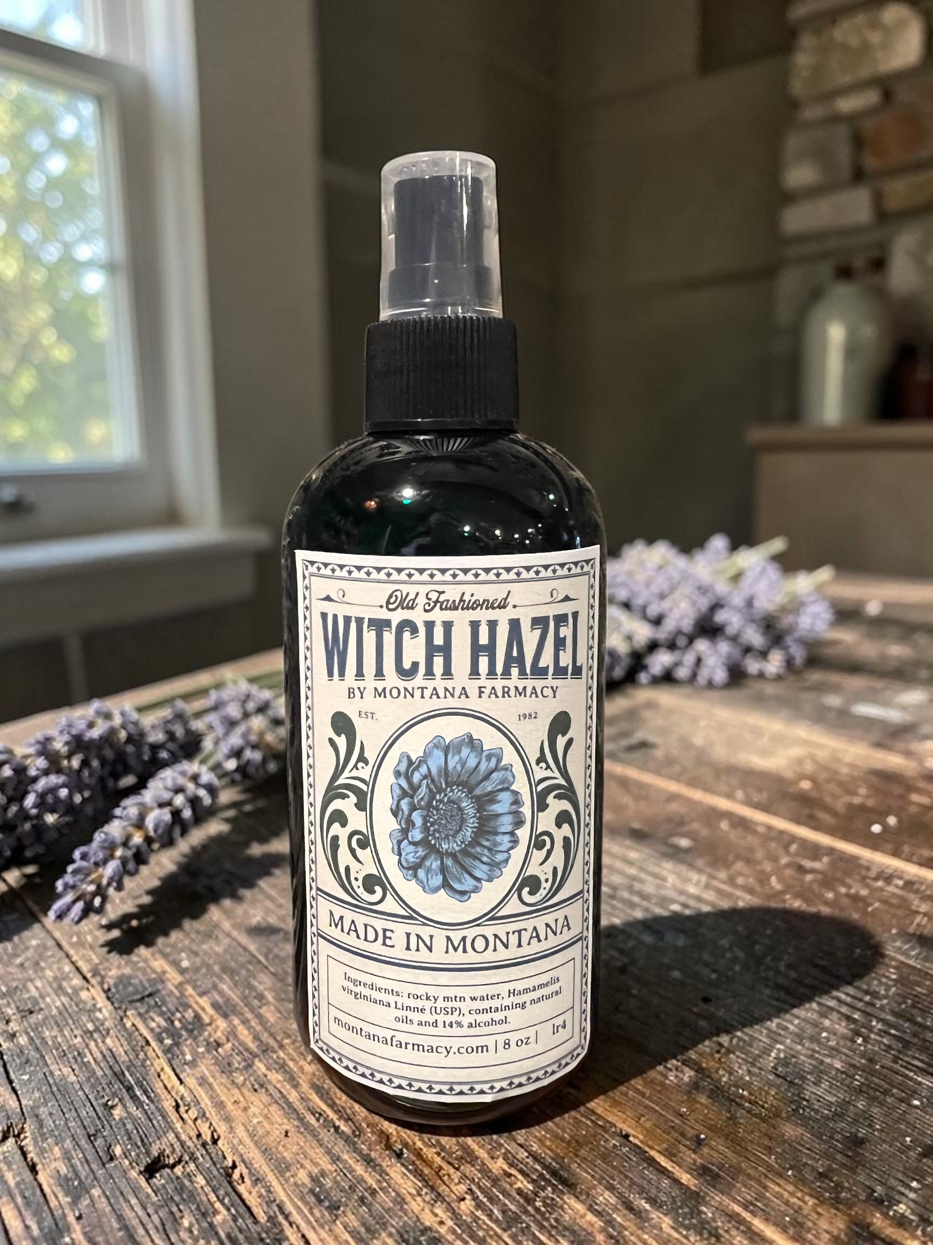 Halloween-Emporium alcohol-free witch hazel toner in a spray bottle with vintage-style label on a rustic wooden table.