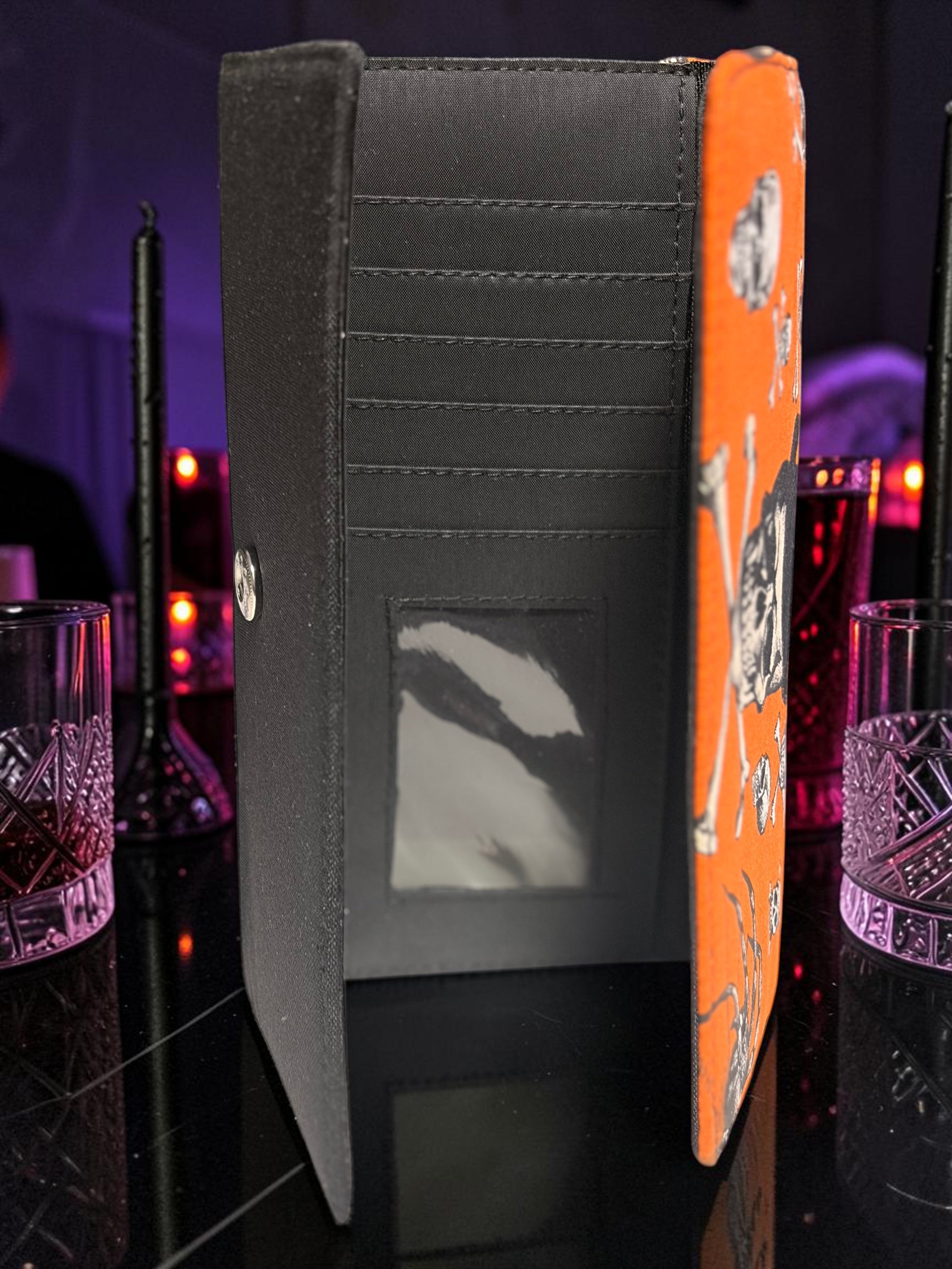 Halloween-Emporium Wolfman clutch wallet open view showing black interior card slots and orange skull print exterior