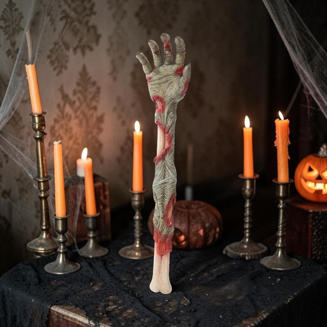 Halloween-Emporium severed zombie arm back scratcher with realistic decaying skin and bone texture on a dark table.