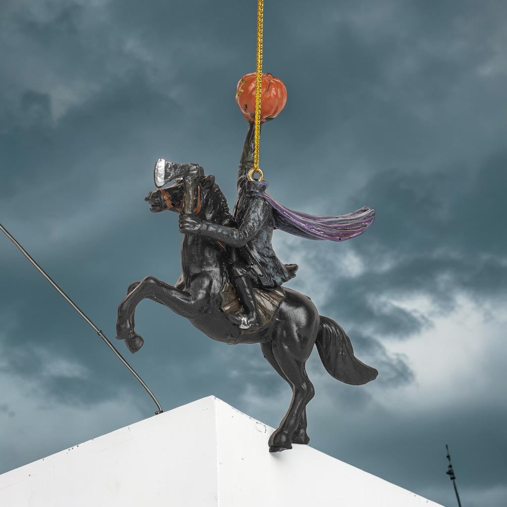 Halloween-Emporium Headless Horseman ornament featuring a rider on a black horse holding an axe and a jack-o'-lantern.