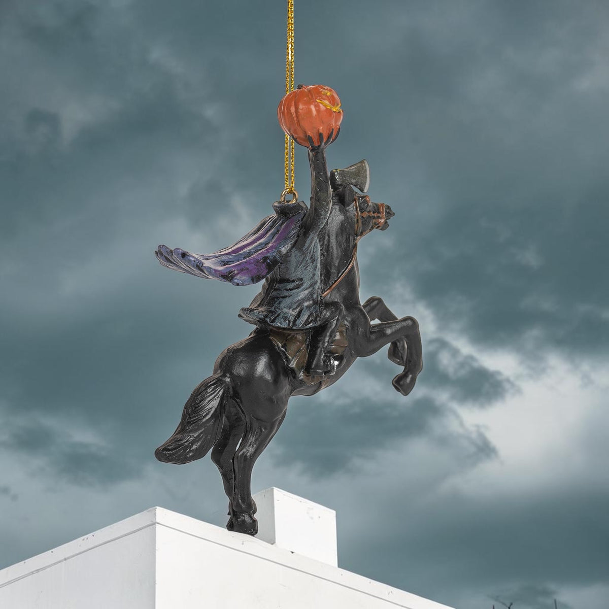 Halloween-Emporium Headless Horseman hanging ornament featuring a black rider on a rearing horse holding a pumpkin.