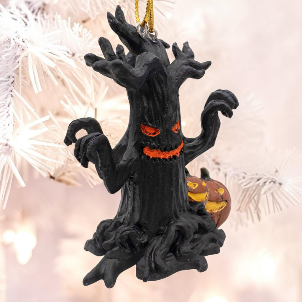 Halloween-Emporium black gnarled tree ornament with glowing orange eyes and a jack-o-lantern, hanging on a white tree.